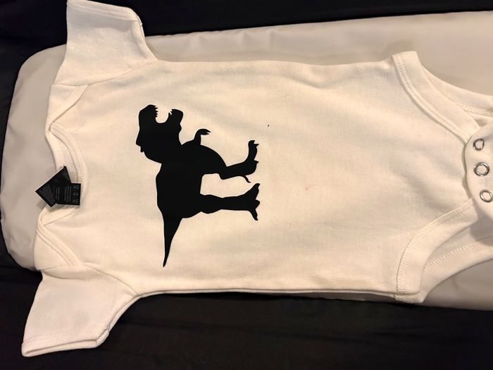 White baby onesie with a custom vinyl silhouette design