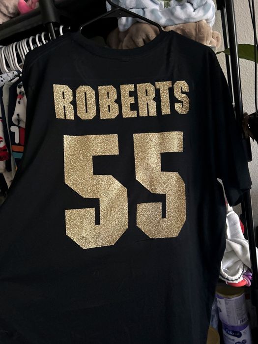 Black shirt with a custom name and number in gold glitter, jersey style